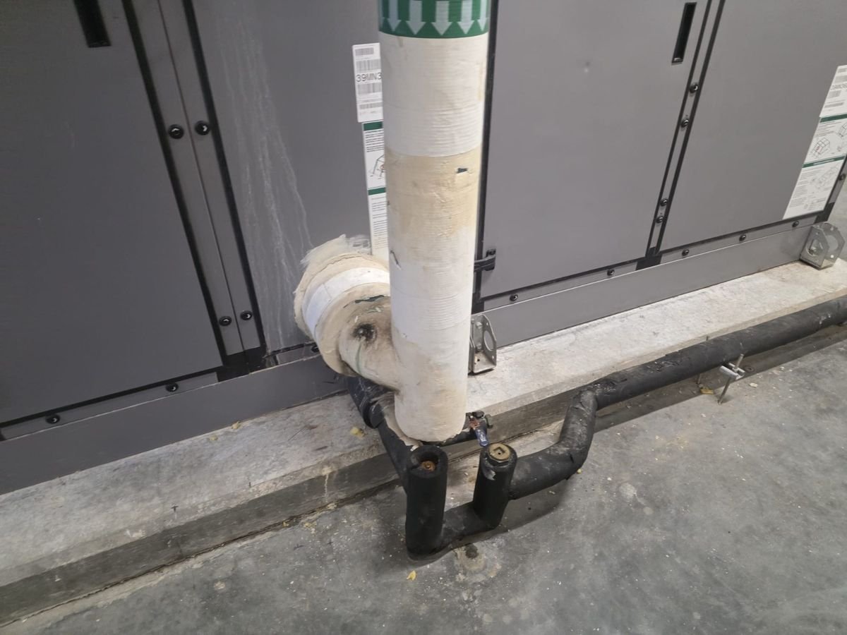 Tuberías junto a la base de concreto de la manejadora de aire industrial